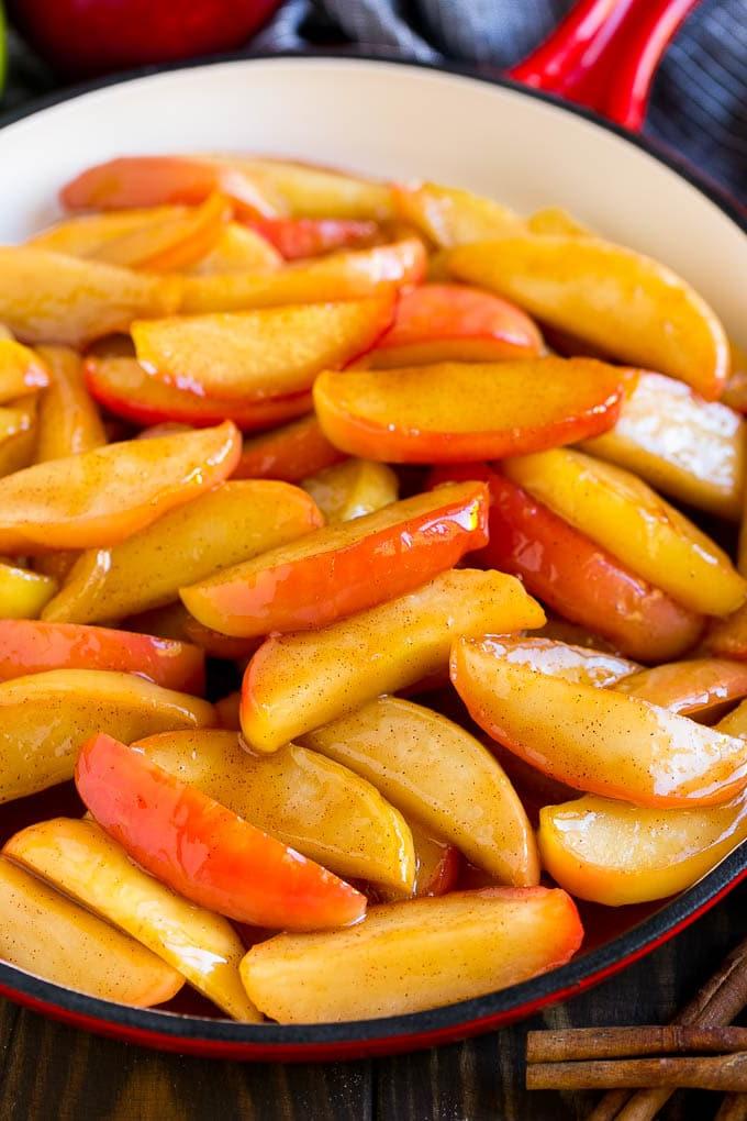 Rezept für Gebratene Äpfel | Sautierte Äpfel | Zimt-Zucker-Äpfel | Eine Süße Beilage oder Dessert für den Herbst Südstaaten-inspirierte gebratene Äpfel, bedeckt mit Butter, Zimt und Zucker in einer roten Pfanne.