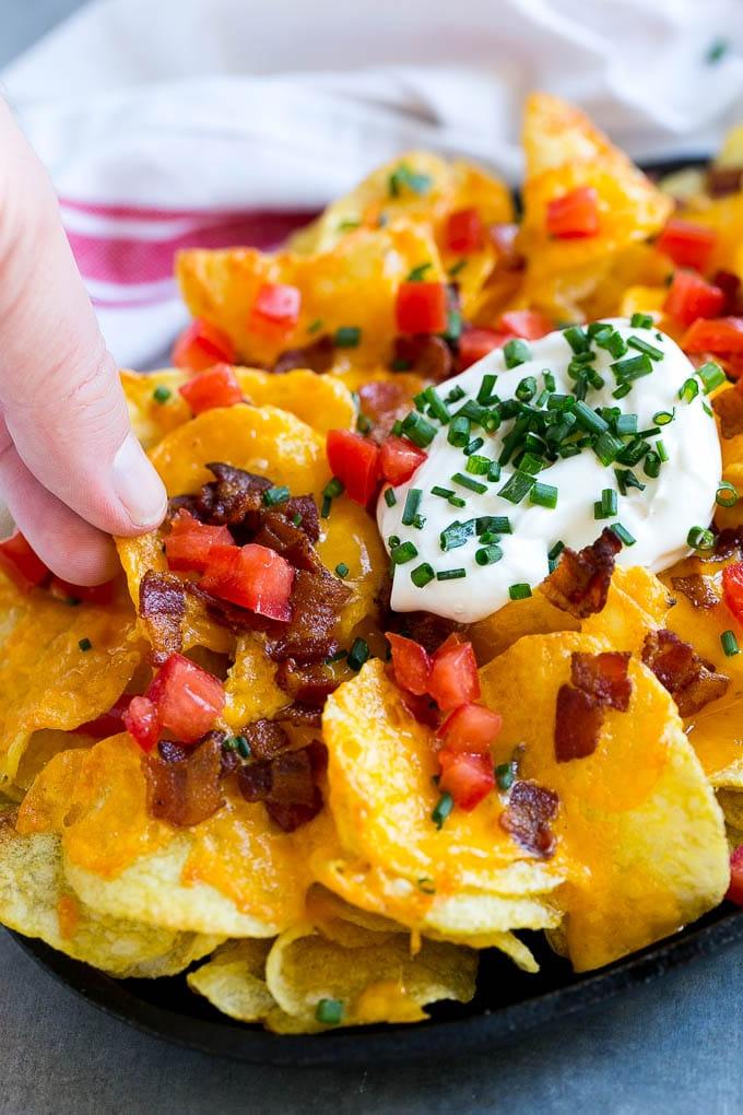 Irische Nachos Rezept | Kartoffel-Nachos | Kartoffelchip-Rezept | Vorspeisen-Rezept #nachos #kartoffeln #käse #speck #vorspeise #ahurt Irische Nachos reichlich belegt mit Käse, Speck, Sauerrahm, Tomaten und Schnittlauch.