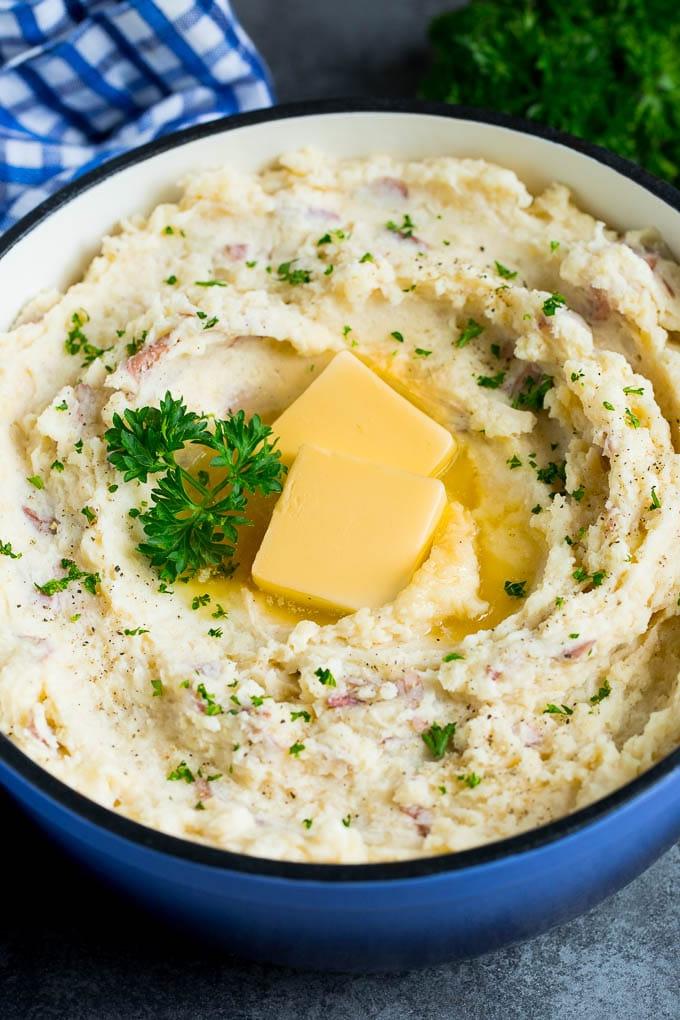 Dieses Kartoffelpüree aus roten Kartoffeln ist zarte Kartoffeln, kombiniert mit Knoblauch, Butter und Gewürzen, um eine einfache und doch völlig befriedigende Beilage zu schaffen. Eine Schüssel mit Kartoffelpüree aus roten Kartoffeln, garniert mit Butter und Petersilie.
