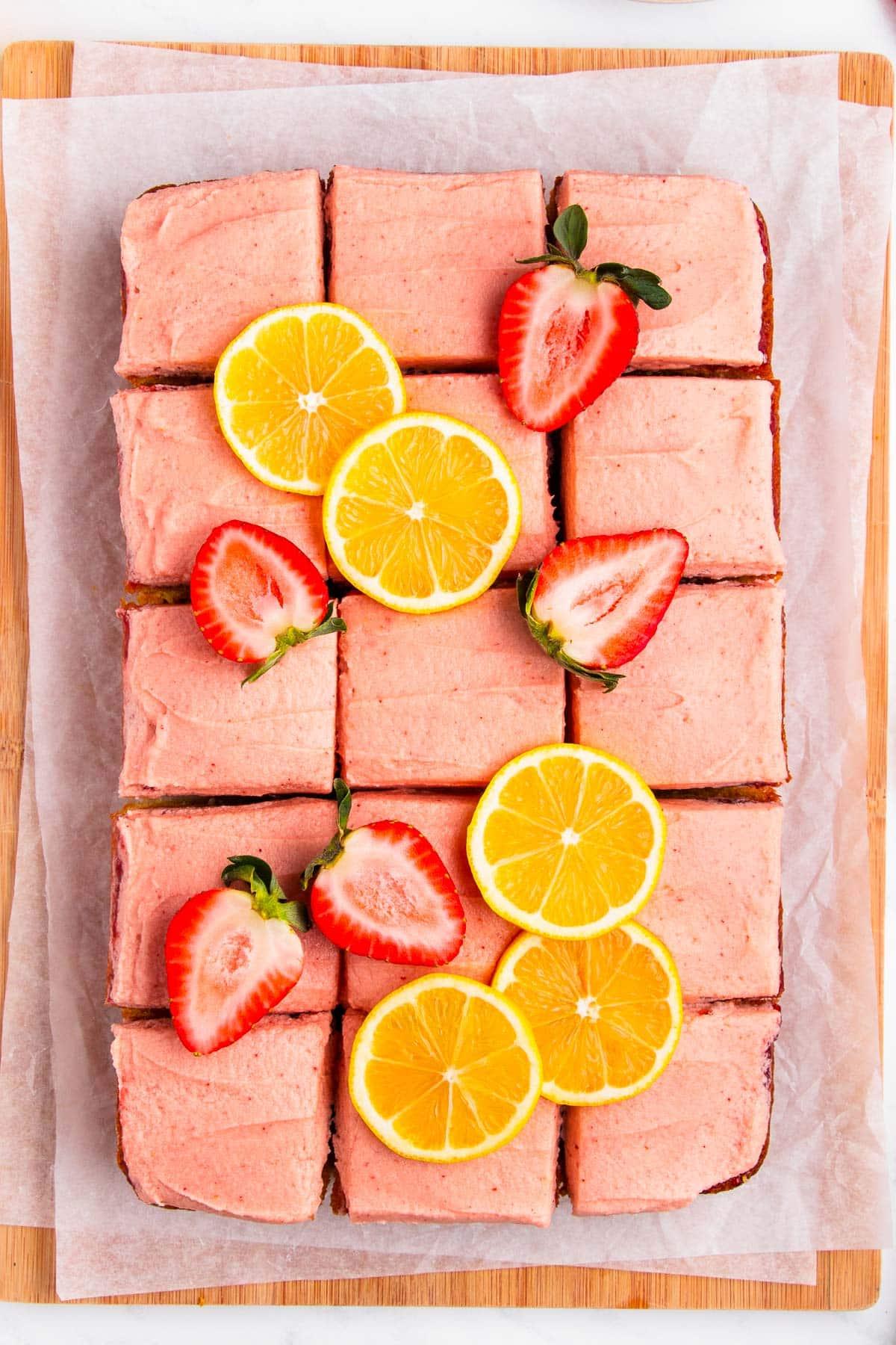 Erdbeer-Zitronen-Kuchen 2 Ein Erdbeer-Zitronen-Kuchen in Quadrate geschnitten und mit frischen Beeren und Zitronenscheiben garniert.