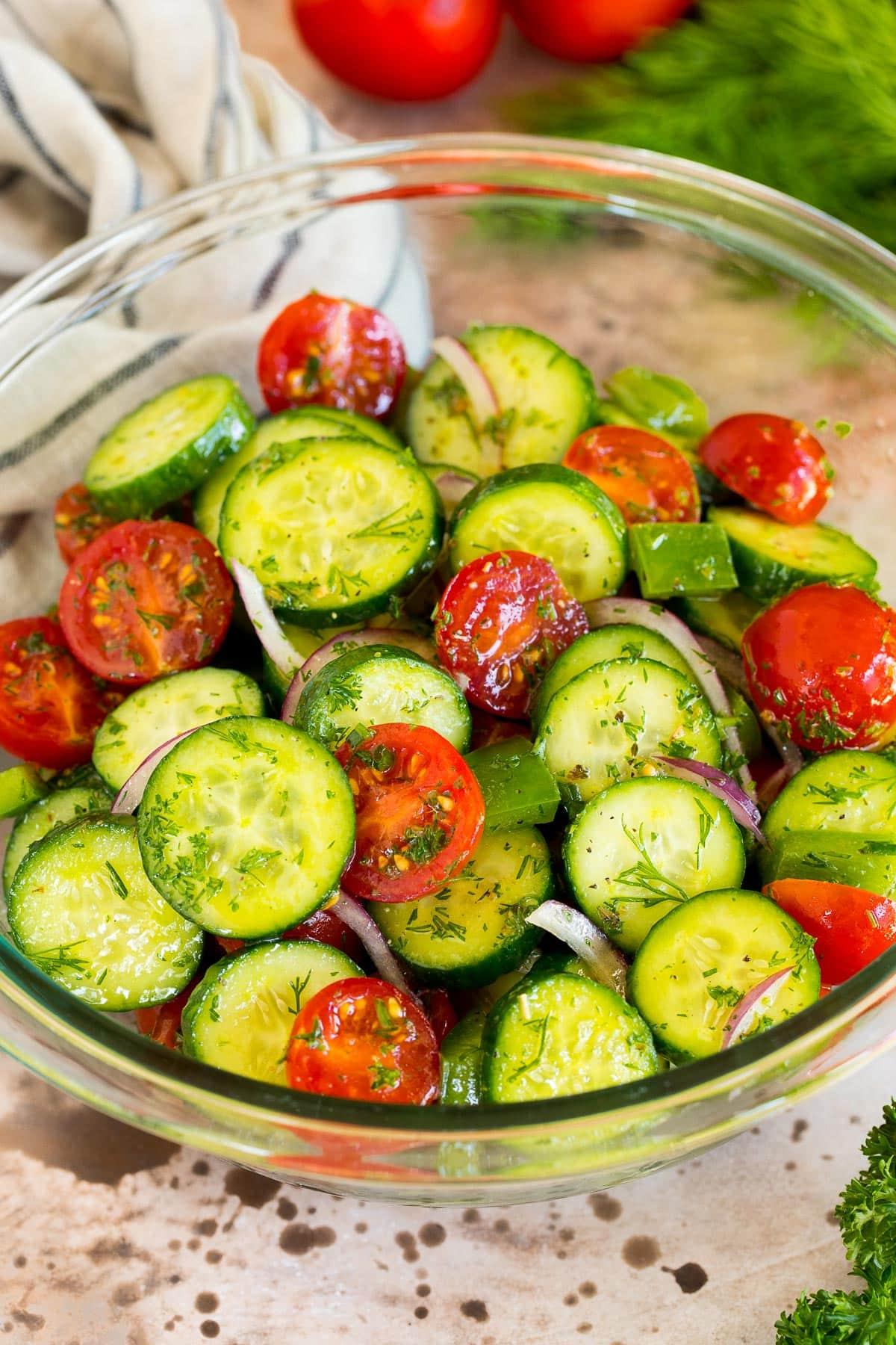Gurken-Tomaten-Salat 2 Eine Schüssel Gurken-Tomaten-Salat, garniert mit frischen Kräutern.