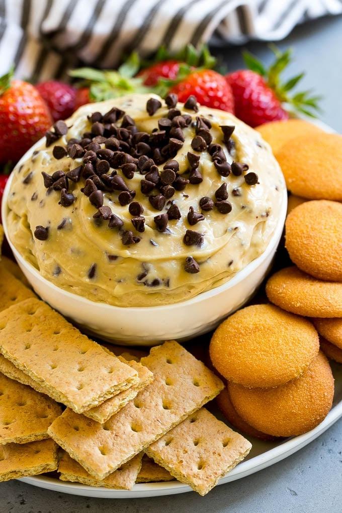 Cookie Dough Dip Rezept | Essbarer Cookie Dough | Schoko-Chip-Keks-Dip #cookies #dip #cookiedough #dessert #snack #ahurt Schoko-Chip-Cookie-Dough-Dip, garniert mit Mini-Schokostückchen und serviert mit Graham Crackern und Vanillewaffeln.
