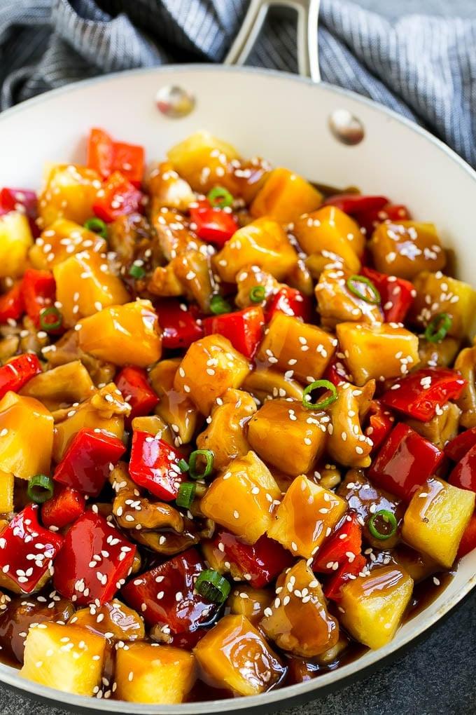 Ananas-Hähnchen | Hawaiianisches Hähnchen | Hähnchen Stir Fry #ananas #hähnchen #abendessen #stirfry #abendessenzuHause Ananas-Hähnchen Stir Fry in einer Pfanne, mit Soße, Sesamsamen und Frühlingszwiebeln garniert.
