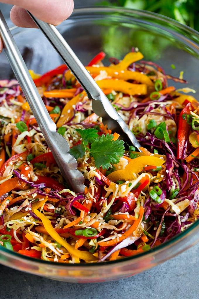 Asiatischer Krautsalat Rezept - Eine frische Beilage Zange, die eine Portion asiatischen Krautsalats serviert.
