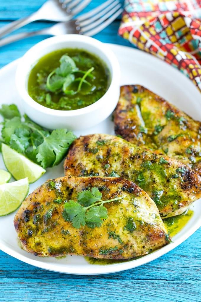 Koriander-Limetten-Hähnchen | Gegrilltes Hähnchen #hähnchen #grillen #koriander #limette #abendessen #ahurt Koriander-Limetten-Hähnchen mit Sauce beträufelt und mit Limettenspalten serviert.
