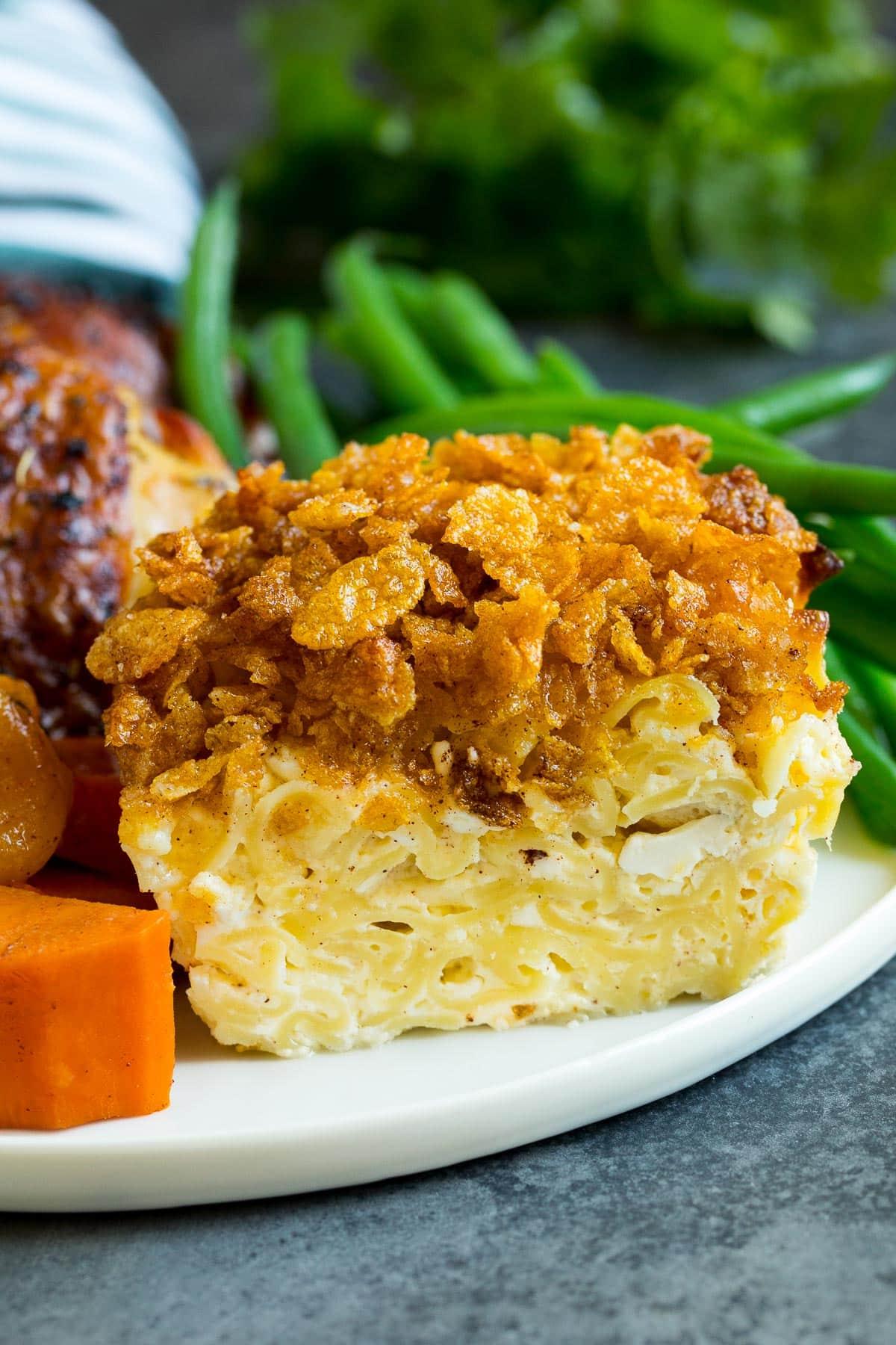 Ein Portion Nudel Kugel auf einem Teller, serviert mit Hühnchen und Gemüse.