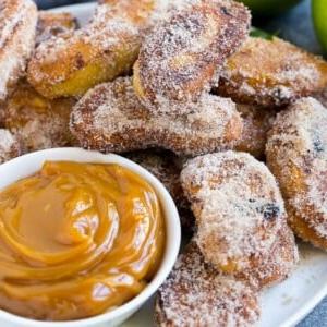 Eine Platte mit Zimt-Zucker-Apfelfritten, serviert mit Karamell-Dip.