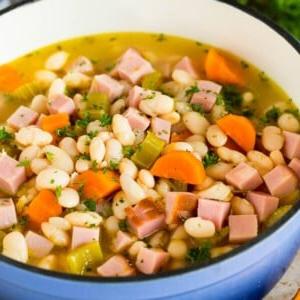 18 Schinkenreste-Rezepte 12 Ein Topf mit Schinken und Bohnen, garniert mit Petersilie.