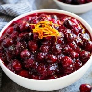 Eine Schüssel Cranberry-Orangen-Sauce, belegt mit frischer Orangenschale.
