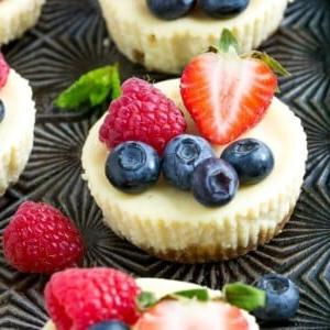 Dieses Rezept für griechische Joghurt-Käsekuchen sind Mini-Käsekuchen, die mit griechischem Joghurt leichter gemacht und mit frischen Beeren belegt wurden. Eine schnelle und einfache süße Leckerei!