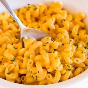 14 Slow Cooker Nudelrezepte 17 Slow Cooker Makkaroni mit Käse, garniert mit Petersilie, mit einem Servierlöffel darin.