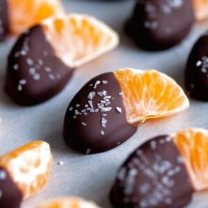 Ein Bild von Orangenscheiben, die zur Hälfte in Schokolade getaucht sind.