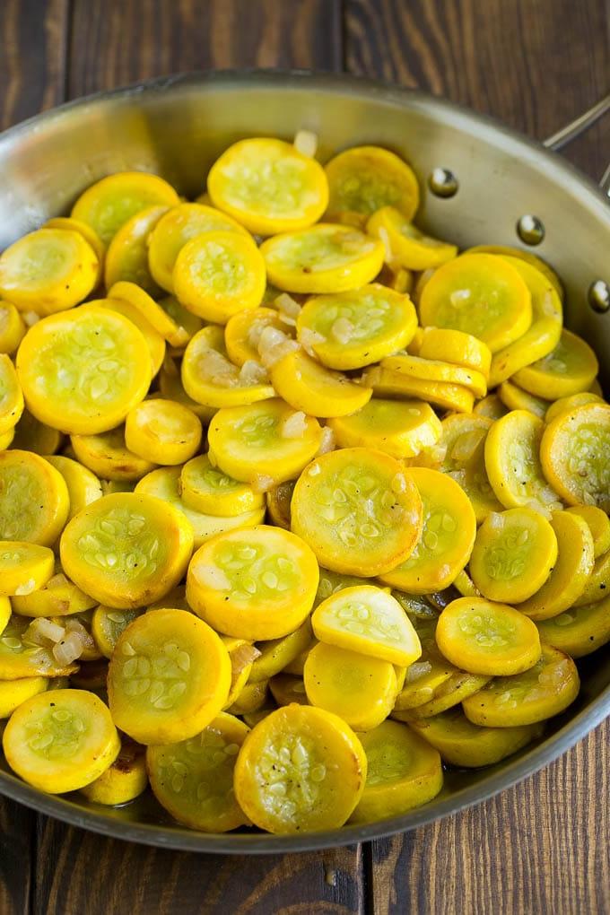 Kürbisauflauf Rezept | Gemüseauflauf | Zucchini Auflauf #auflauf #kürbis #zucchini #käse #beilage #abendessenimzoo Gelber Kürbis und Zwiebeln in einer Bratpfanne.