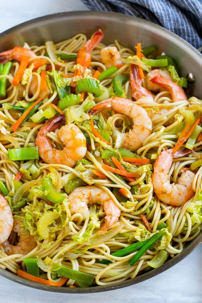 Eine Pfanne voller Garnelen Chow Mein Nudeln mit Gemüse.