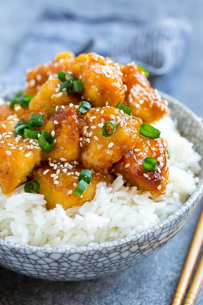 Orangen-Hähnchen aus dem Slow Cooker, serviert über einer Schüssel Reis.