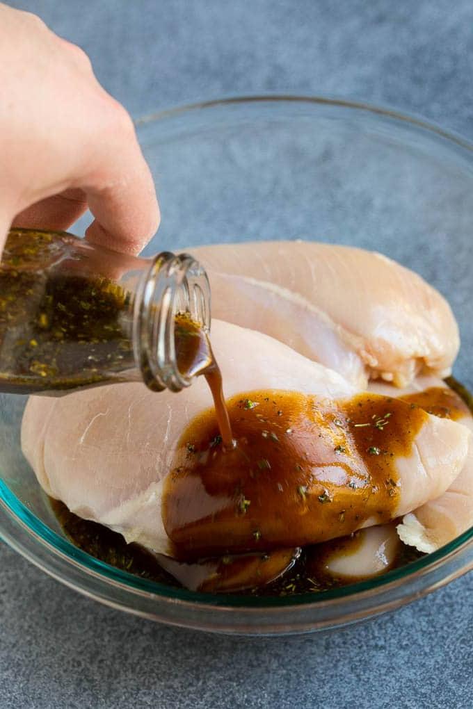 Hähnchenmarinade wird über Hähnchenbrüste ohne Haut gegossen.
