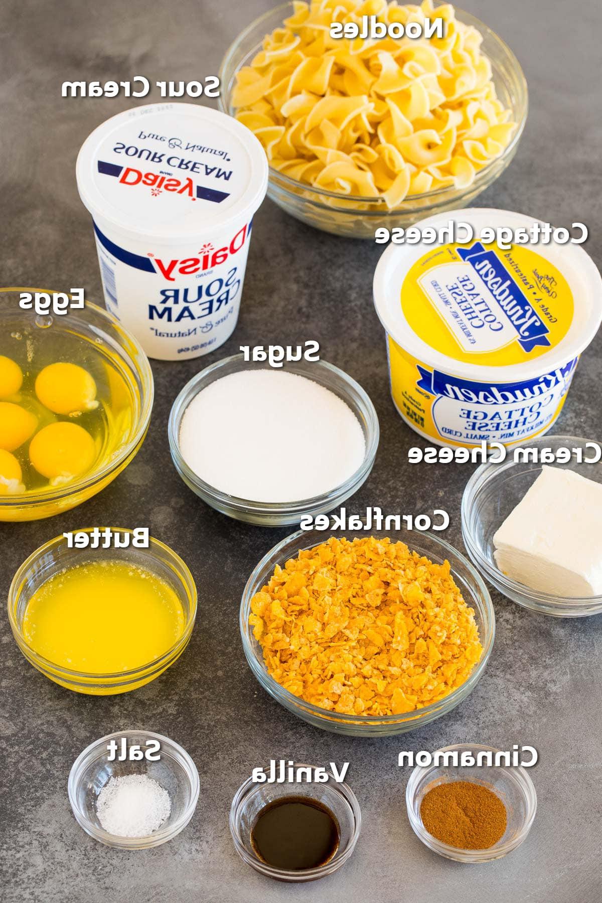 Schüsseln mit Zutaten, darunter Nudeln, Milchprodukte, Eier, Gewürze und Cornflakes.