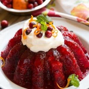 Himbeer-Gelatine wird mit Cranberry-Sauce, Ananas und Orangenschale für eine köstliche Beilage oder Dessert kombiniert, das perfekt für die Feiertage ist.