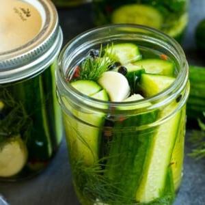 Ein Glas Kühlschrankgurken mit Gurkenscheiben, Knoblauch und Dill.