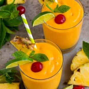Tropische Smoothies, garniert mit Minze, Limetten und Ananas.