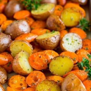 Geröstete Kartoffeln und Karotten mit Knoblauch und frischen Kräutern.