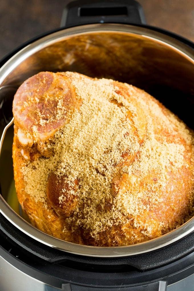 Dieser Instant Pot Schinken ist ein Spiral-Schinken, der mit einer 3-Zutaten-Glasur überzogen und dann im Schnellkochtopf zu zarter Perfektion gegart wird. Mit braunem Zucker bedeckter Schweinebraten in einem Schnellkochtopf.