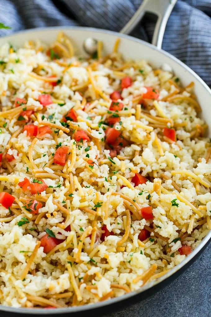Hausgemachtes Rice-A-Roni mit Tomaten und Kräutern garniert, alles in einer Pfanne.