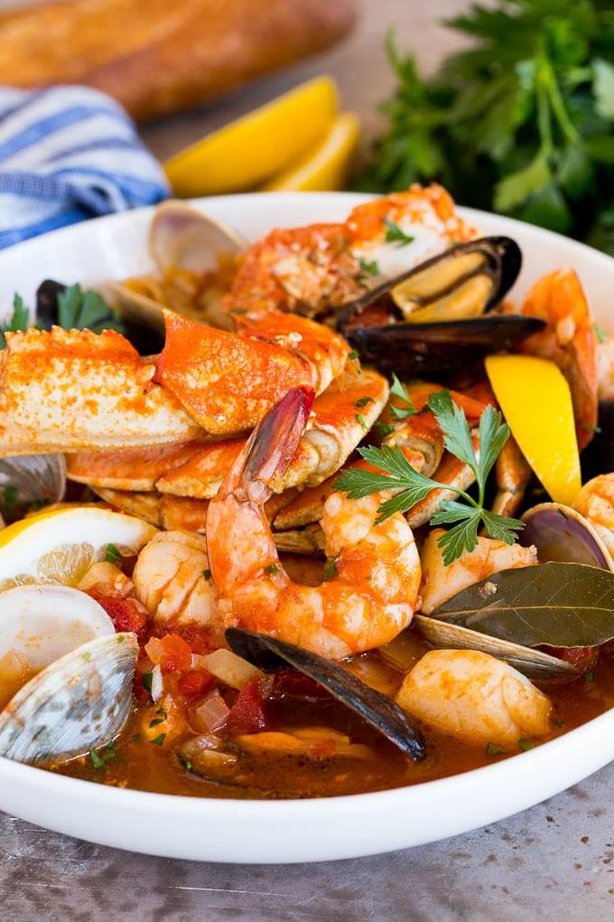 Eine große, appetitliche Schüssel Cioppino, prall gefüllt mit gegarten Dungeness-Krabben, saftigen Garnelen und verschiedenen Schalentieren, bereit zum Servieren.