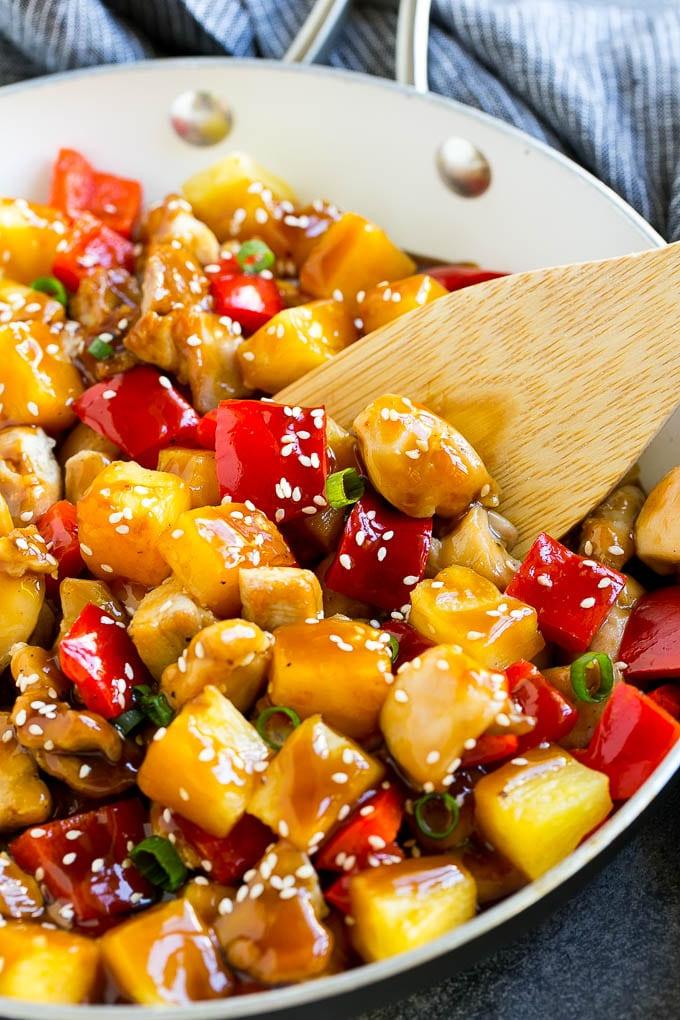 Ananas-Hähnchen | Hawaiianisches Hähnchen | Hähnchen Stir Fry #ananas #hähnchen #abendessen #stirfry #abendessenzuHause Eine Pfanne mit Ananas-Hähnchen und einem Holzspatel darin.