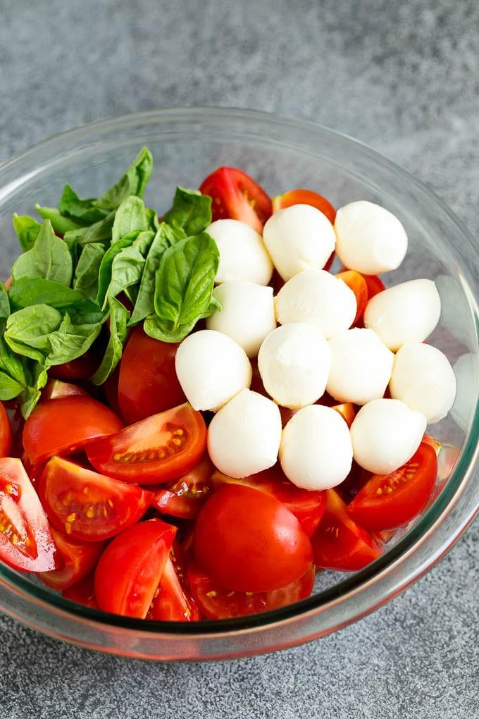 Caprese Salad Recipe | Tomato Salad #salad #tomato #mozzarella #cheese #basil #caprese #summer #ahurt Tomaten, Mozzarella und Basilikum in einer Schüssel.