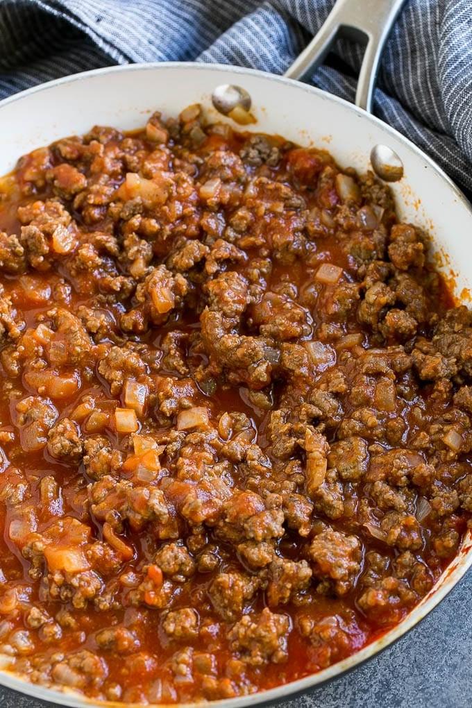 Gewürztes Hackfleisch und Tomatensoße in einer Pfanne.