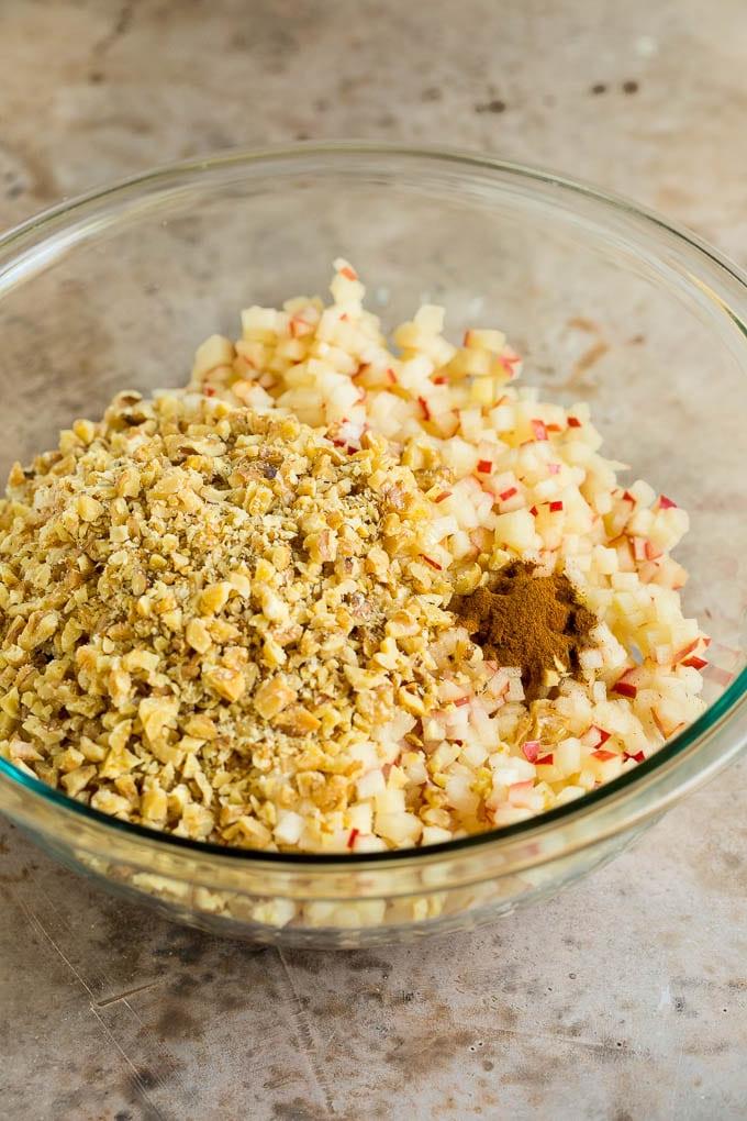 Dieses Charoset Rezept ist eine Mischung aus Äpfeln, Walnüssen und Honig, die zusammen eine süße Paste bilden, die ein wesentlicher Bestandteil jeder Passah-Mahlzeit ist. Äpfel, Wein, Zimt und Honig, alles in einer Schüssel.