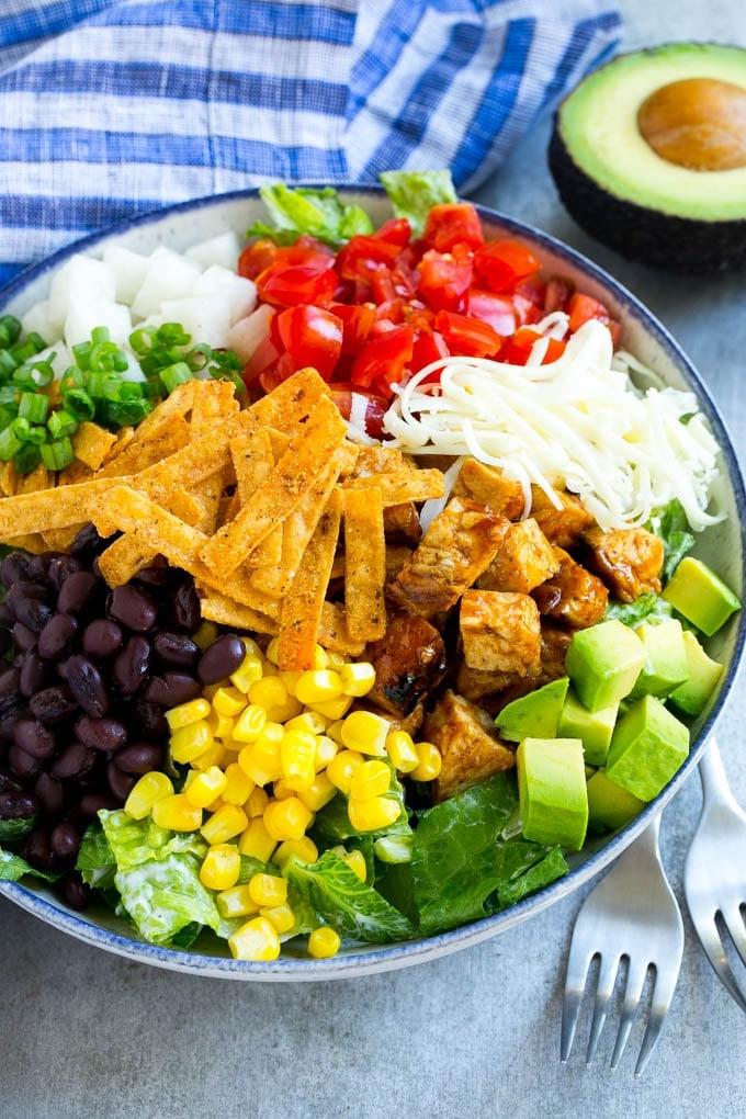 BBQ-Hähnchensalat 2 Eine Schüssel mit Salaten, BBQ-Hähnchen, Mais, Bohnen, Avocado, Tomaten und Käse.