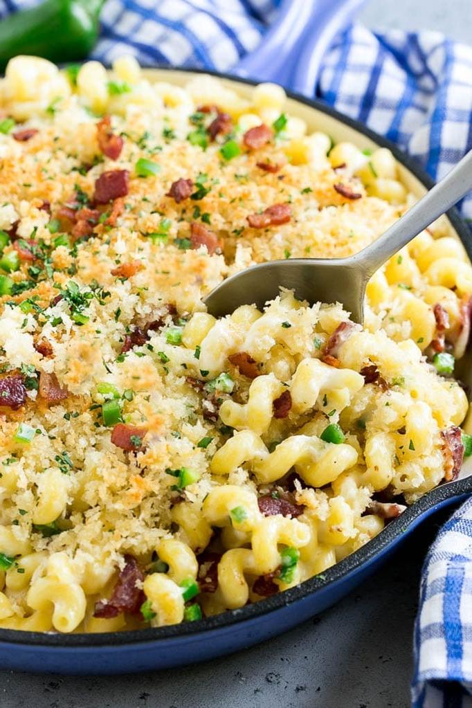 Eine Pfanne mit Jalapeño Popper Mac and Cheese, belegt mit knusprigen Semmelbröseln, Koriander und Bacon.