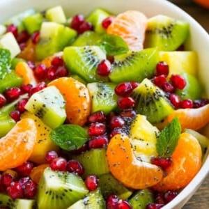 Dieser Winterfruchtsalat ist eine farbenfrohe Vielfalt an frischem Obst, die in einem leichten Honig-Mohn-Dressing gewendet wird.