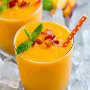 Ein Pfirsich-Smoothie in Eis, garniert mit Minze.