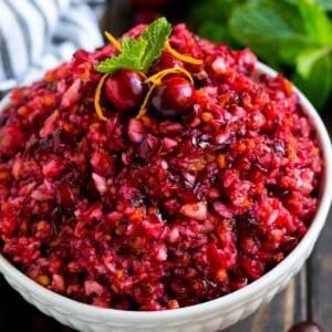 Eine Schüssel Cranberry-Relish, belegt mit ganzen Cranberries, Orangenschale und Minze.