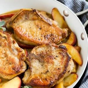 Eine Pfanne mit Apfel-Schweinekoteletts.