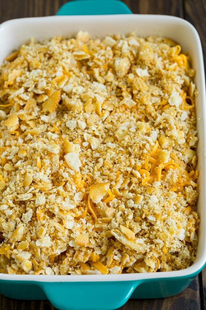 Kürbisauflauf Rezept | Gemüseauflauf | Zucchini Auflauf #auflauf #kürbis #zucchini #käse #beilage #abendessenimzoo Kürbis in einer Auflaufform mit Kekskrümeln und Cheddar-Käse belegt.