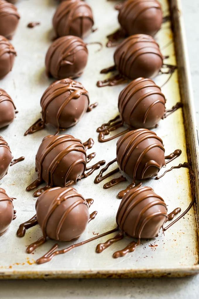 Schokolierte Kirschen Rezept | Kirsch-Pralinen | Kirsch-Bonbons #schokolade #süßigkeiten #dessert #kirsche #sweets #ahurt Schokolierte Kirschen auf einem Backblech mit Schokoladenüberzug.