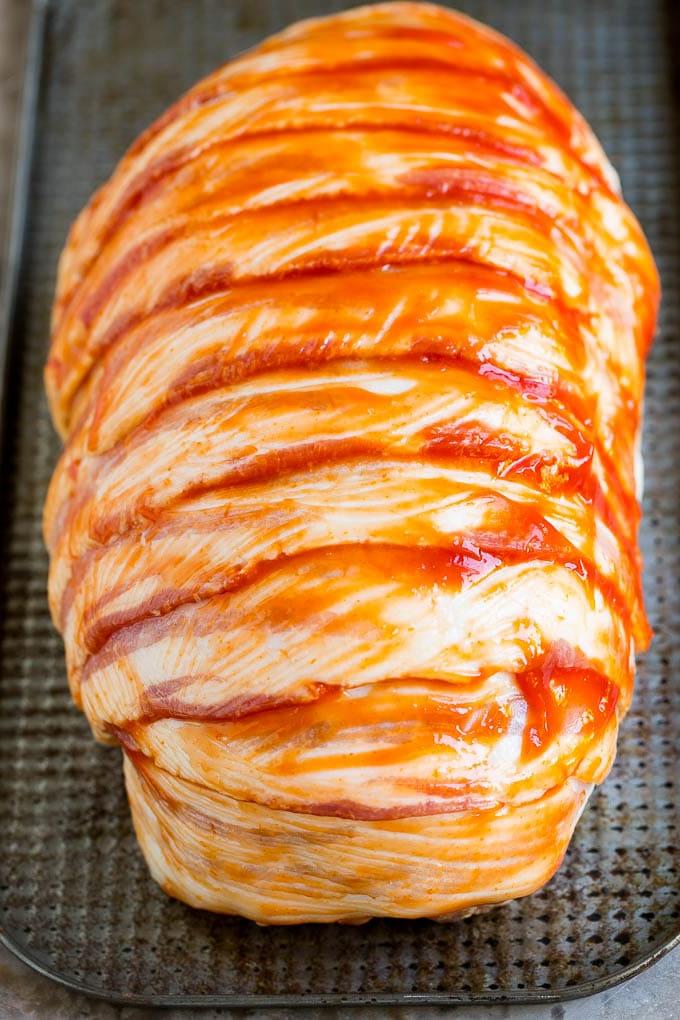 Hackbraten im Speckmantel Rezept | Rinderhackbraten #hackbraten #rindfleisch #rinderhack #speck #abendessen #abendessenimzoo Rohe Scheiben Speck, die um einen gewürzten Rinderhackfleischlaib gewickelt sind.