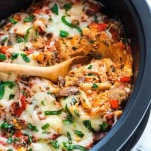 14 Slow Cooker Nudelrezepte 5 Ein Bild von Crock Pot Pasta im Crock Pot mit einem Holzlöffel in der Pasta.