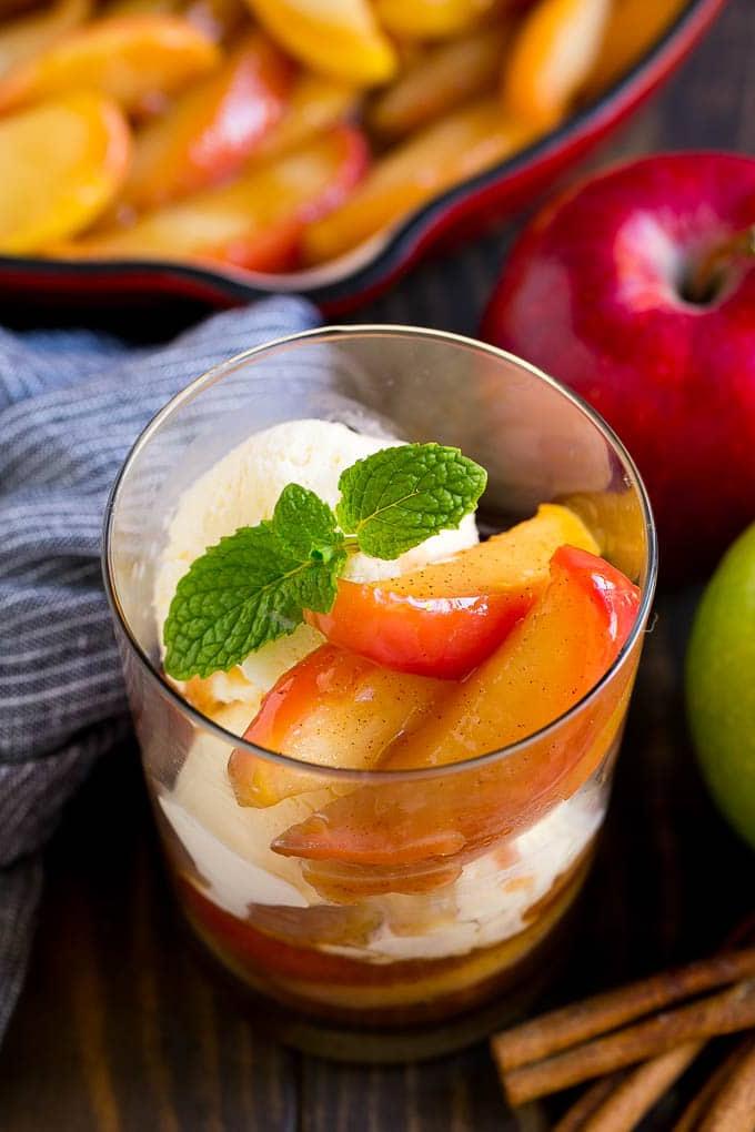 Rezept für Gebratene Äpfel | Sautierte Äpfel | Zimt-Zucker-Äpfel | Eine Süße Beilage oder Dessert für den Herbst Eine Schale mit gebratenen Äpfeln, serviert mit Vanilleeis und garniert mit frischer Minze.