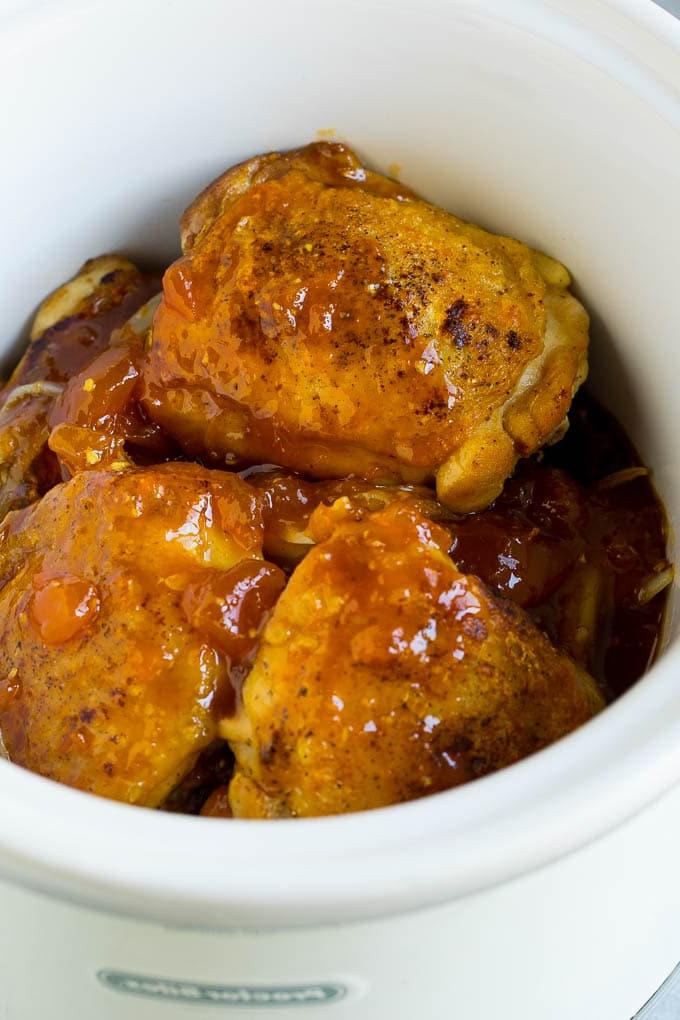 Hähnchenschenkel im Slow Cooker, übergossen mit einer Sauce aus Aprikosenmarmelade, Sojasauce und Ingwer.