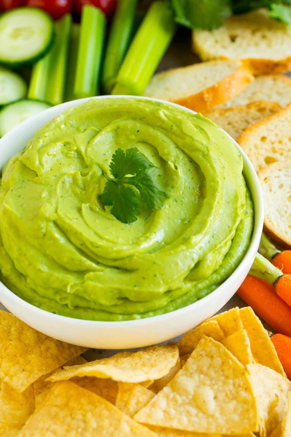 Cremiger Dip in einer weißen Schüssel, serviert mit Tortilla-Chips.