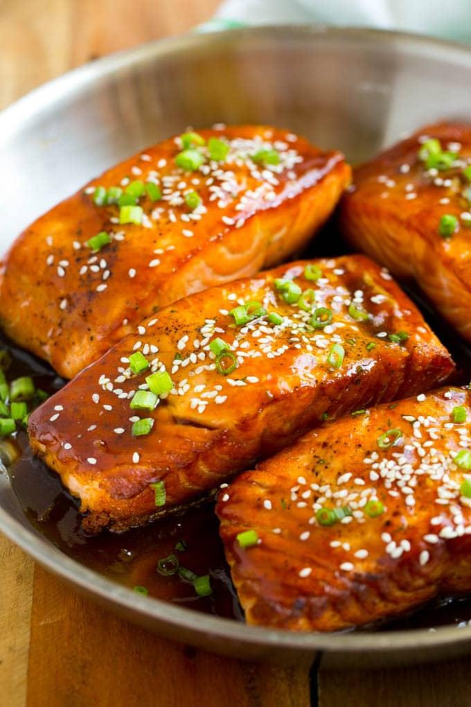 Eine Pfanne voll Lachs Teriyaki Filets, übergossen mit Sauce und garniert mit Sesam.