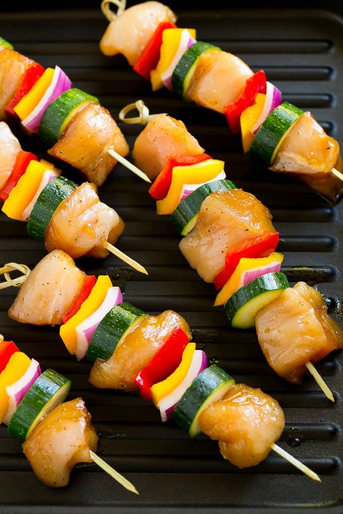 Gegrillte Hähnchenspieße auf einer Grillpfanne.