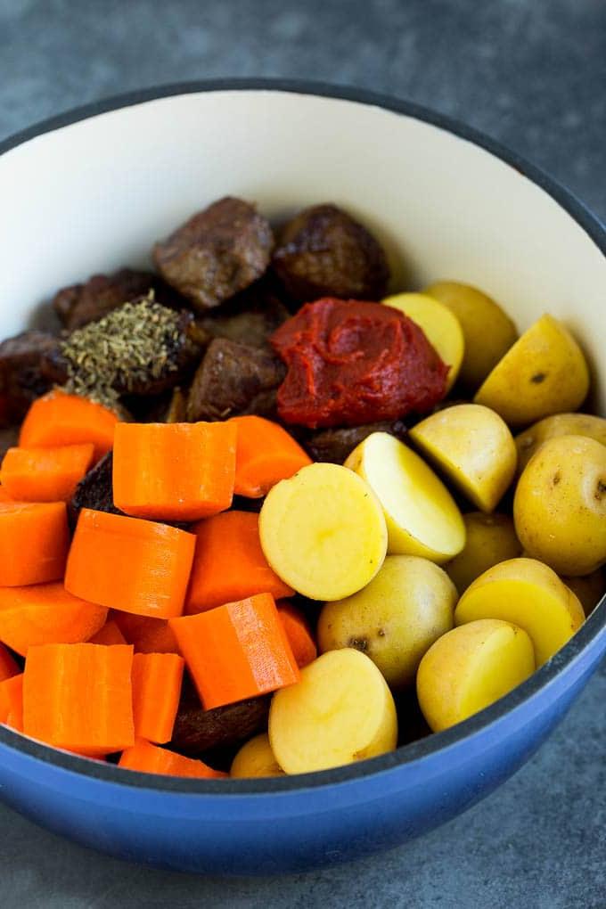Rindfleisch, Kartoffeln, Karotten und Tomatenmark im Topf für Irischen Eintopf.