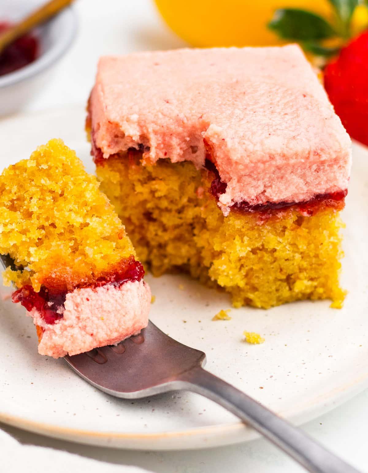 Erdbeer-Zitronen-Kuchen 6 Ein Stück Erdbeer-Zitronen-Kuchen mit einer Gabel, die ein Stück abschneidet.