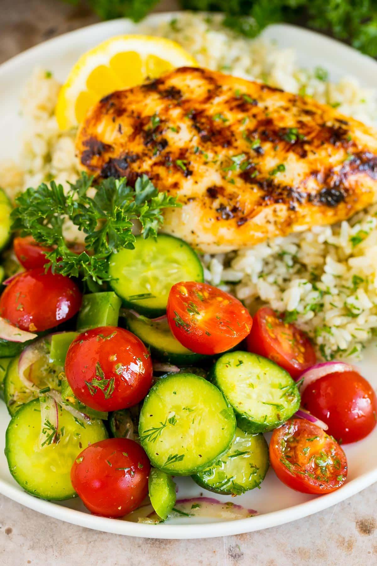 Gurken-Tomaten-Salat 6 Gurken-Tomaten-Salat serviert mit gegrilltem Hähnchen und Reis.